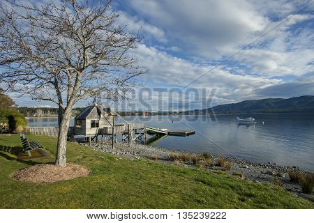 water plane floating over fresh water lake against beautiful mountain scenery in lake te anau new zealand