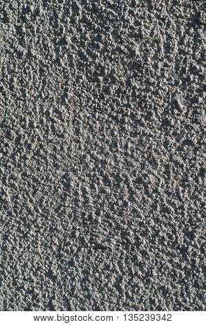 Background of a gray stucco coated and painted exterior rough cast of cement and concrete wall texture decorative coating