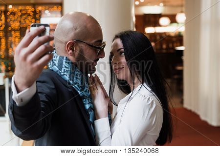 Arab businessman and girl making selfie in the shopping center