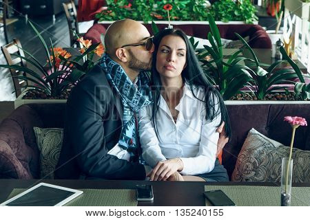 Arab man hugs and kisses a beautiful girl in the restaurant