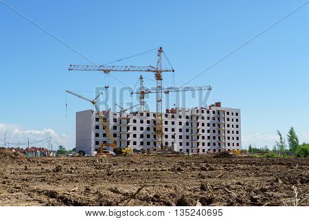 The construction of a multistory building. Construction cranes are on the building site