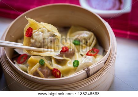 Steamed chinese dimsum on steamer with sweet and sour sauce