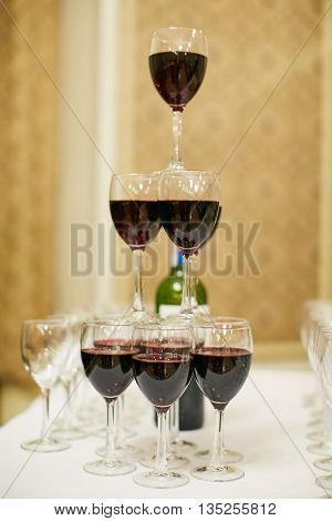 pyramid of glasses with red wine on table