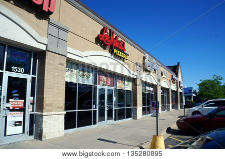 JOLIET, ILLINOIS / UNITED STATES - JUNE 1, 2015: One may eat pizza at Lou Malnati's Pizzeria, in a Joliet strip mall.