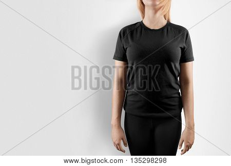 Blank black t-shirt design mockup. Women stand near wal in gray tshirt clear template front mock up. Empty female apparel uniform singlet model. Sweat tee shirt plain dress surface ready for print.