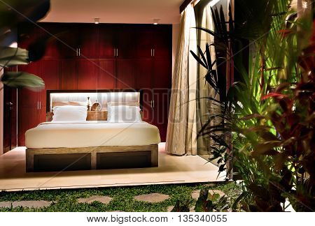 Illuminated Bedroom At Night Near The Garden With Trees