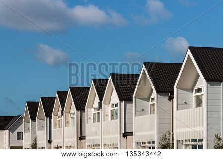 row of white houses against blue sky