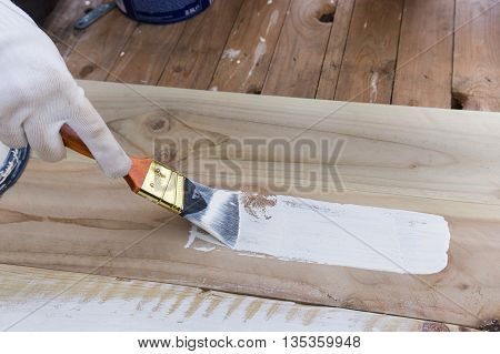 Painting timber boards outside with the white paint or white coloured emulsion using 2 inches painting brush.