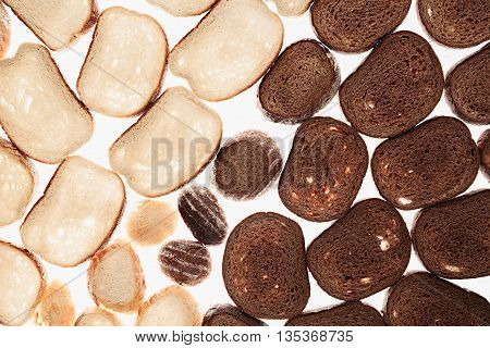 Slices of black rye bread and white bread on a white background. Food background. Pattern.