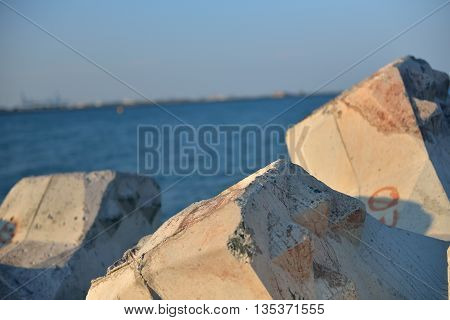 Close Up Of Breakwater Made Of Concrete Tetrapods In The Sunset, With The Calm Sea In Background. Se
