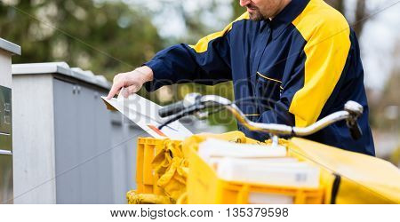 Postman delivering letters to mailbox of recipient