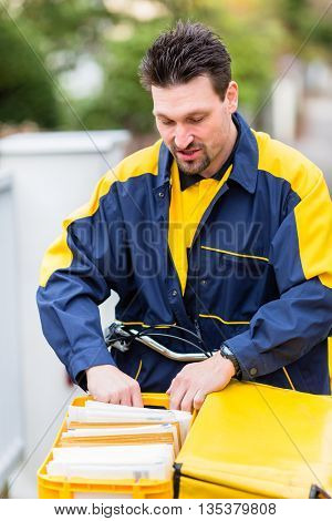 Postman delivering letters to mailbox of recipient