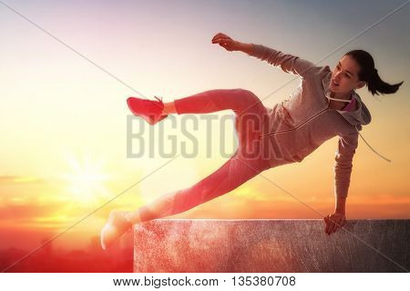 young sporty woman outdoors. the girl is engaged in parkour.