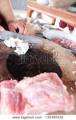 The process of cutting raw beef and entrails on a cutting board closeup