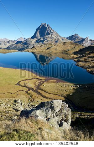 Midi Dossau Peak reflected in Gentau lake. Ossau Valley, Pyrenees National Park, Pyrenees, France.