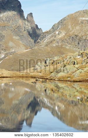 Midi Dossau Peak reflected in a lake. Ossau Valley, Pyrenees National Park, Pyrenees, France.