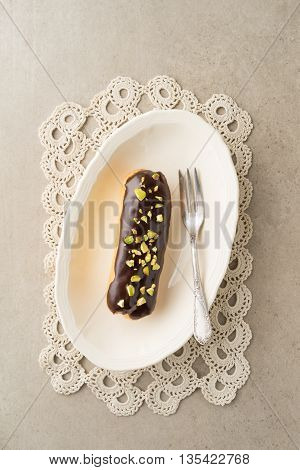 Eclair with chocolate ganache with pistachio topping