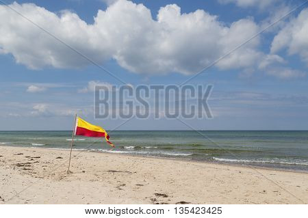 Red and yellow swimming area flag at Tisvilde beach in Denmark.