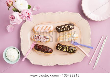 Eclairs with chocolate ganache and icing with different toppings