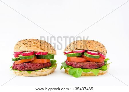 Vegan beetroot burger with lamb's lettuce, tomato, cucumber and radish isolated on white background