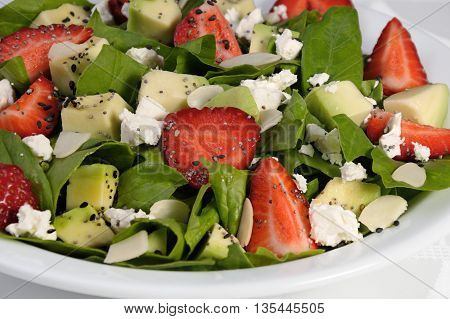 Salad spinach with strawberries avocado ricotta and sesamepoppy seeds