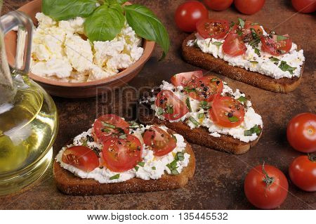 Bruschetta with ricotta and cherry tomatoes seasoned spices basil