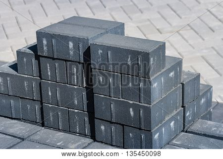 close up of grey paving stones with finished pavement in background