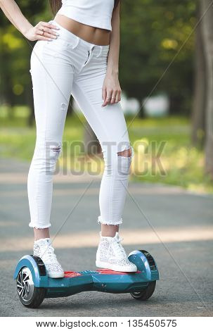 Girl using a self-balancing two-wheeled board. The gyroscope based dual wheel electric scooter is also called a smart balance wheel. Feet on hover board scooter