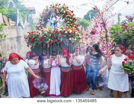 PANCHIMALCO EL SALVADOR - MAY 08 : Salvadoran girls carry an altar with a statue of Virgin Mary during the procession of the Flower & Palm Festival in Panchimalco El Salvador on May 08 2016