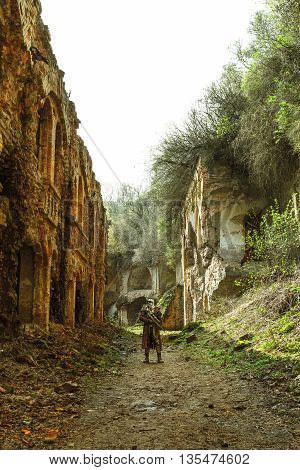 Nuclear post-apocalypse. Sole survivor in tatters and gas mask on the ruins of the destroyed city