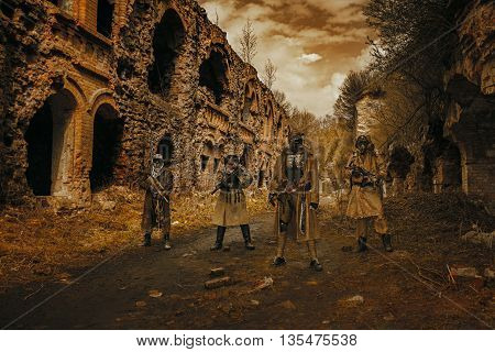 Nuclear post-apocalypse. Survivors in tatters and gas mask on the ruins of the destroyed city