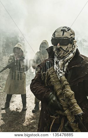 Nuclear post-apocalypse. Survivors in tatters and gas mask on the ruins of the destroyed city