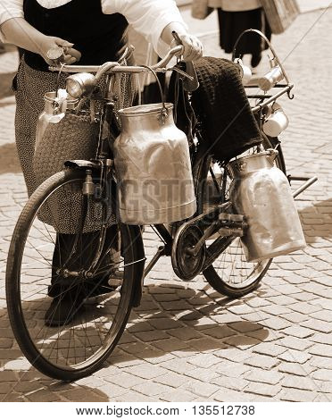Woman Carrying Milk Cans With A Old Bicycle