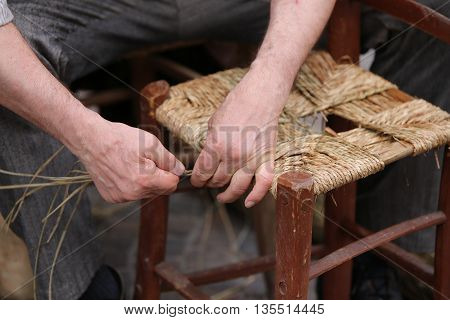 Hands Of Elder Repairer Of Chairs Along The Street