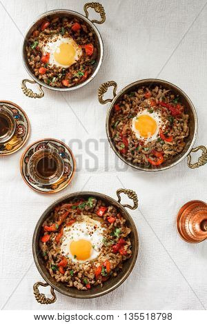Fried egg with mince meat in traditional turkish pan top view