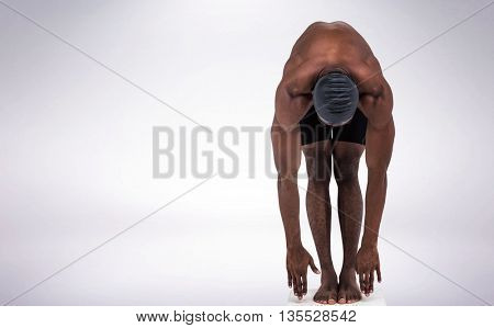 Swimmer ready to dive against grey background