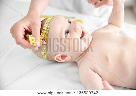 Professional pediatrician examining smiling baby