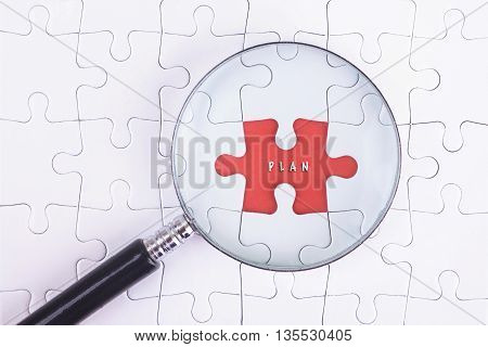 Business Concept - Magnifier Glass on white puzze with PLAN Word