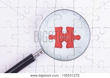 Business Concept - Magnifier Glass on white puzze with 2017 Word