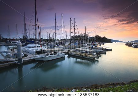 Beautiful composition view of Malaysian Harbour with a yatch during sunset. Noise slighty appear and soft focus due to long exposure