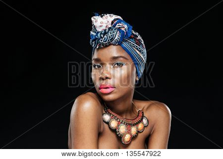 Close-up portrait of an attractive afro american woman looking at camera isolated on the black background