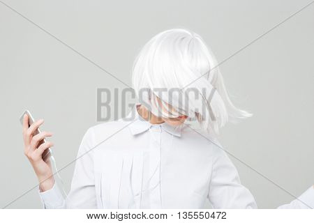 Attractive young woman with blonde hair listening to music from cell phone and dacing