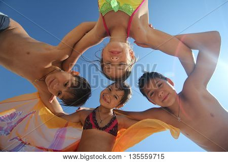 Group of five young people in circle looking at camera