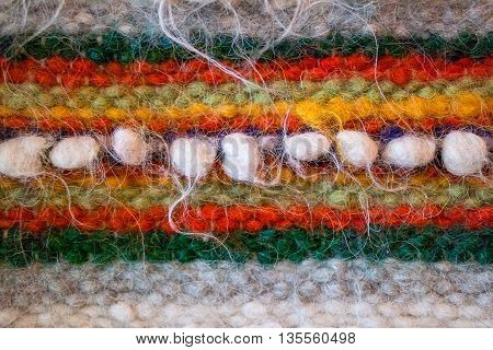 Traditional Ukrainian woven woolen fabric from the Carpathian mountains region. Ethnic pattern in orange red and green colors. Tradition huzul ornament.