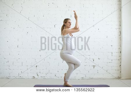 Pregnant Young Woman Doing Prenatal Yoga. Eagle Pose