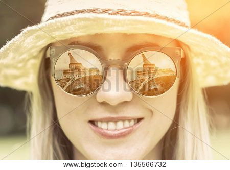 Woman in sunglasses and hat with traval images.