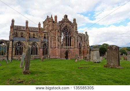 The ruins of pink colored Melrose Abbey in the Scottisch Borders region in Scotland