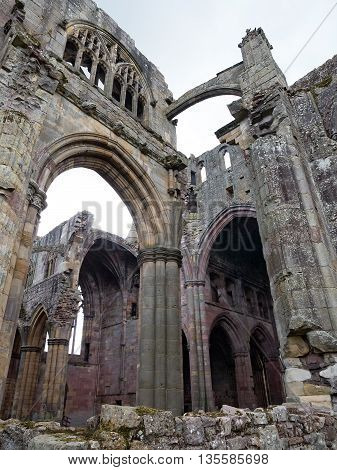 The ruins of pink colored Melrose Abbey in the Scottisch Borders region in Scotland