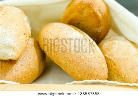 Selection of delicous bread buns lying in basket, as seen from above.