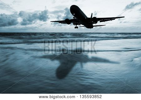 Dark airplane with blurred seascape long exposure technique and cloud storm and in twilight